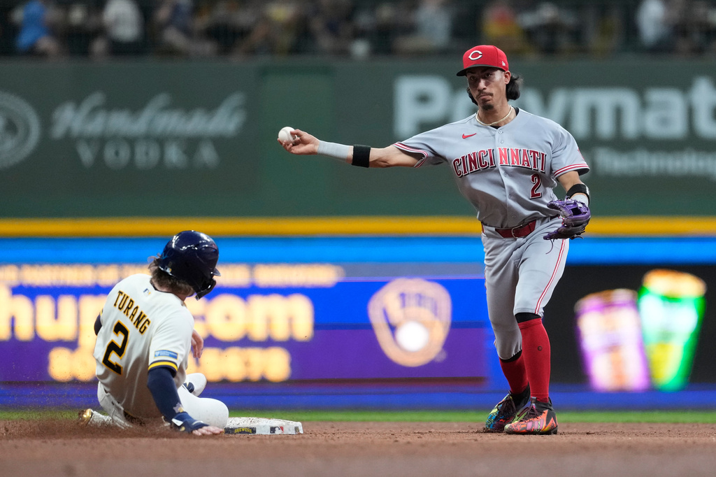 Cincinnati Reds' Edwin Arroyo, right, throws to first base to turn a double play after tagging Milwaukee Brewers' Brice Turang out at second during the sixth inning of a baseball game Tuesday, June 30, 2026, in Milwaukee. (AP Photo/Aaron Gash)