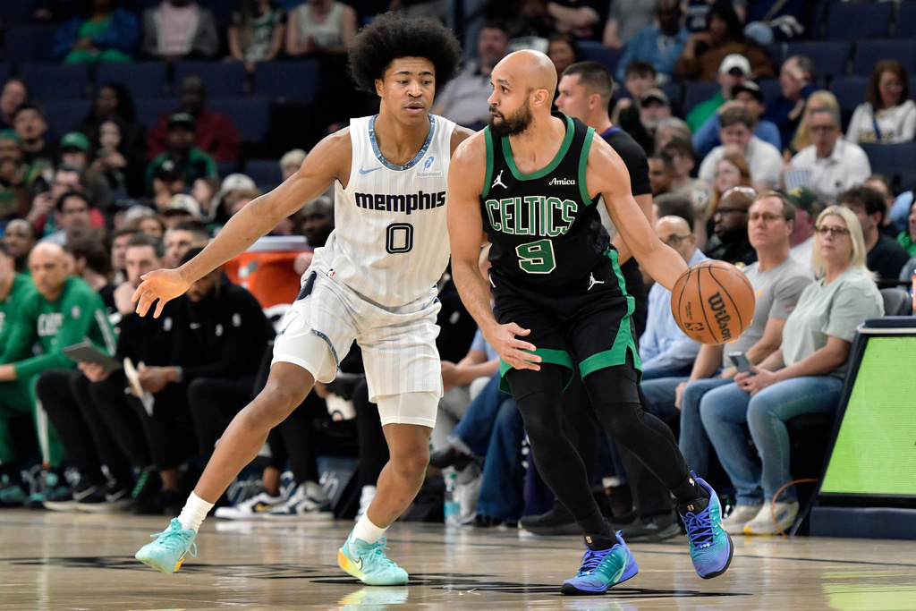 Boston Celtics guard Derrick White (9) handles the ball against Memphis Grizzlies forward Jaylen Wells (0) in the first half of an NBA basketball game Friday, March 20, 2026, in Memphis, Tenn. (AP Photo/Brandon Dill)