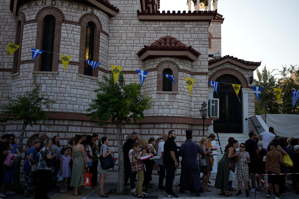 Pilgrims wait in line to have their Fanouropites, orange-flavored cakes, blessed at the Church of St. Fanourios in Athens, Wednesday, Aug. 26, 2026. (AP Photo/Thanassis Stavrakis)