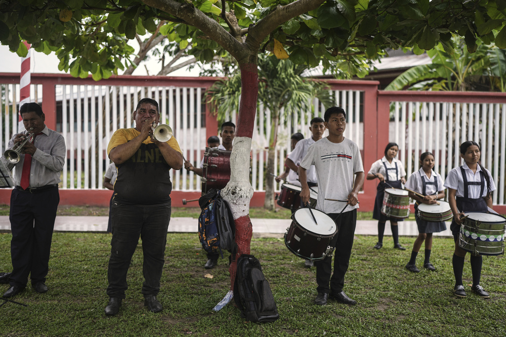 A band plays during a flag-raising ceremony in Santa Rosa, Peru, an island on the Amazon River at the center of a territorial dispute with Colombia, Sunday, Aug. 17, 2025. (AP Photo/Ivan Valencia)
