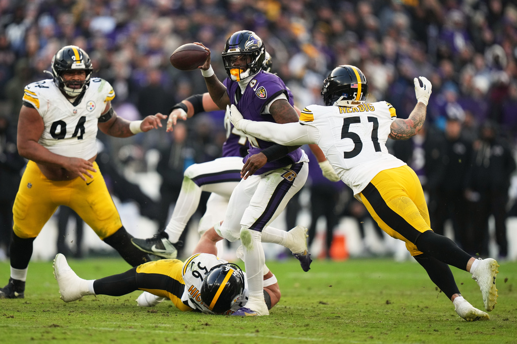 Pittsburgh Steelers linebacker Alex Highsmith (56) and linebacker Nick Herbig (51) tackle Baltimore Ravens quarterback Lamar Jackson (8) during the second half of an NFL football game, Sunday, Dec. 7, 2025, in Baltimore. (AP Photo/Stephanie Scarbrough)
