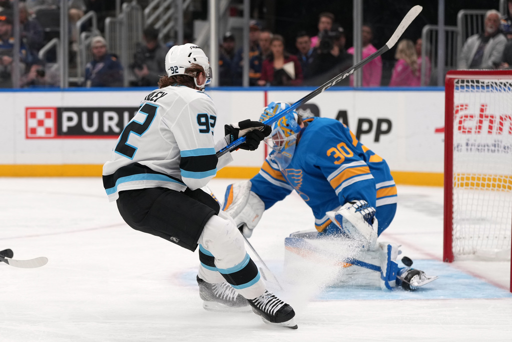Utah Mammoth's Logan Cooley (92) scores past St. Louis Blues goaltender Joel Hofer (30) during the first period of an NHL hockey game Thursday, Oct. 23, 2025, in St. Louis. (AP Photo/Jeff Roberson)