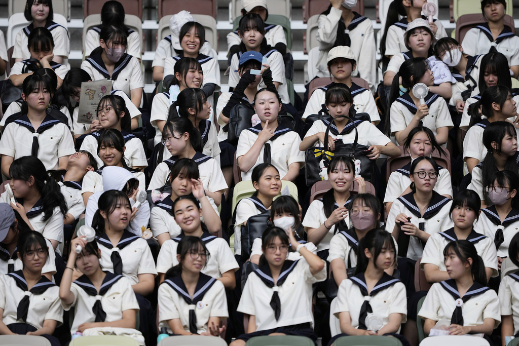 School girls attend the first session of the World Athletics Championships in Tokyo, Saturday, Sept. 13, 2025. (AP Photo/Matthias Schrader)
