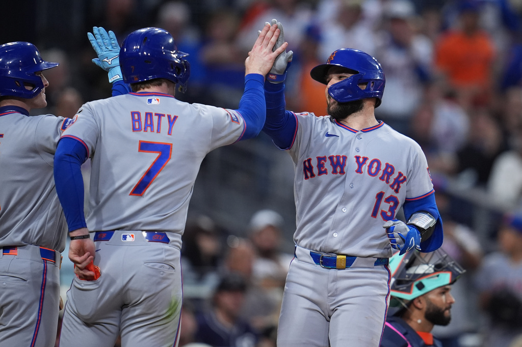 New York Mets' Luis Torrens (13) celebrates with teammates Carson Benge, left, and Brett Baty after hitting a two-run home run during the fifth inning of a baseball game against the San Diego Padres Friday, June 5, 2026, in San Diego. (AP Photo/Gregory Bull)