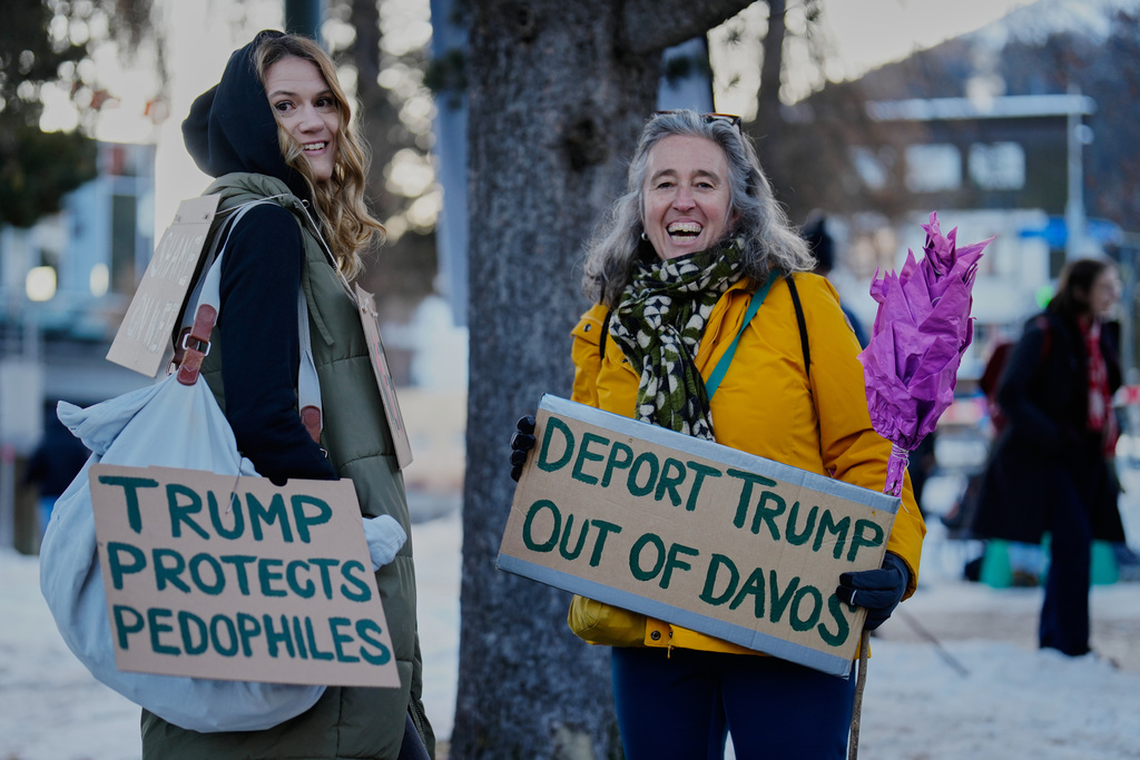 Two women with posters attend a demonstration against United States President Donald Trump and the Annual Meeting of the World Economy Forum in Davos, Switzerland, Sunday, Jan. 18, 2026. (AP Photo/Markus Schreiber)