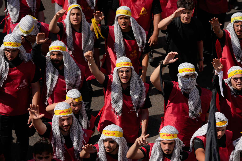 Hezbollah supporters shout slogans, as they march during the holy day of Ashoura that commemorates the 7th century martyrdom of the Prophet Muhammad's grandson Hussein, in Dahiyeh, Beirut's southern suburbs, Lebanon, Friday, June 26, 2026. (AP Photo/Hussein Malla)