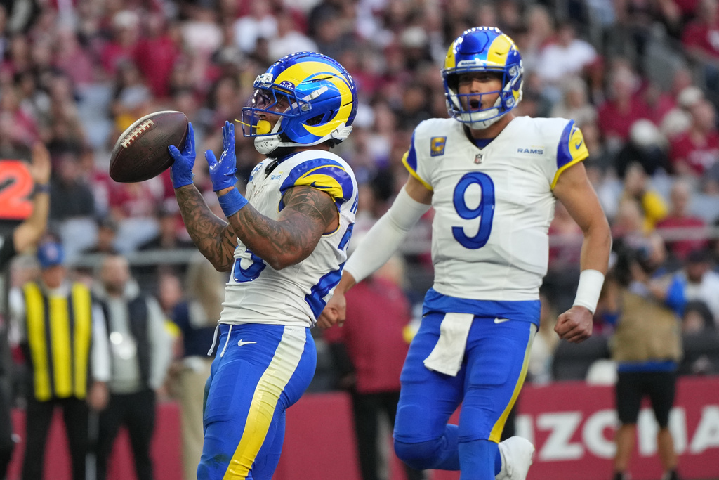 Los Angeles Rams running back Kyren Williams, left, celebrates after scoring a touchdown with quarterback Matthew Stafford, right, in the first half of an NFL football game against the Arizona Cardinals, Sunday, Dec. 7, 2025, in Glendale, Ariz. (AP Photo/Rick Scuteri)