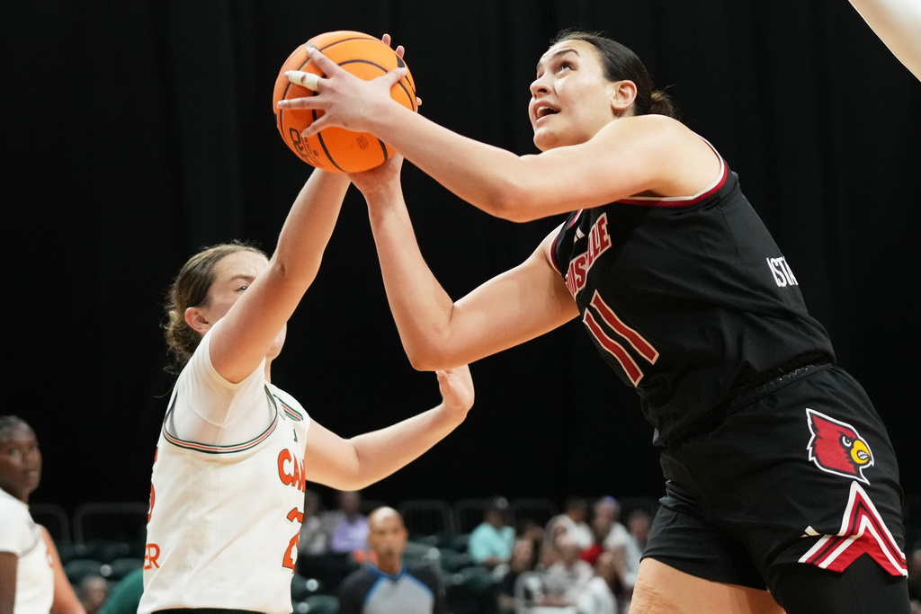 Louisville forward Elif Istanbulluoglu (11) goes to the basket as Miami guard Simone Pelish, left, defends during the first half of an NCAA college basketball game, Thursday, Jan. 8, 2026, in Coral Gables, Fla. (AP Photo/Lynne Sladky)