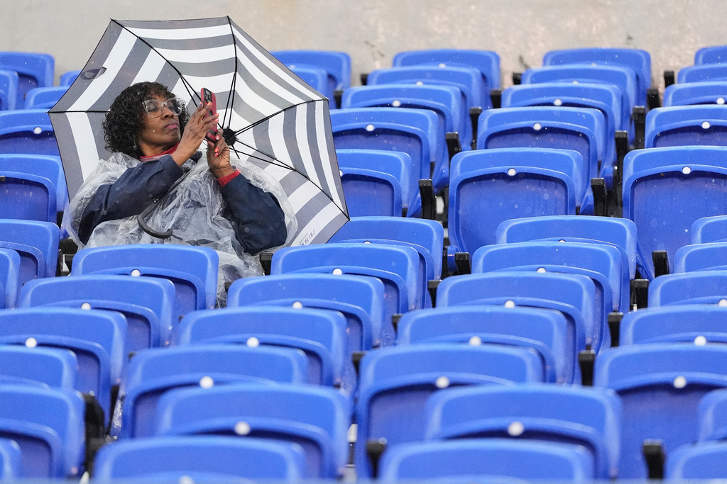 A fan sits in the rain before the Liberty Bowl NCAA college football game between Navy and Cincinnati, Friday, Jan. 2, 2026, in Memphis, Tenn. (AP Photo/George Walker IV)
