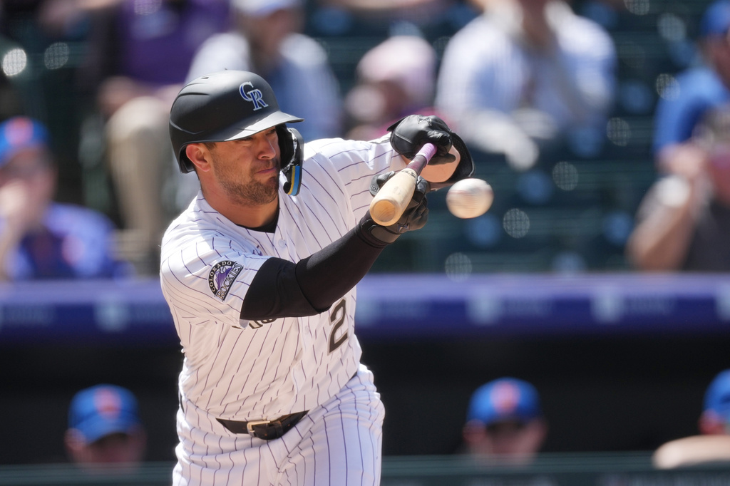 Colorado Rockies' Tyler Freeman puts down a bunt single against New York Mets starting pitcher Christian Scott in the fourth inning of a baseball game Thursday, May 7, 2026, in Denver. (AP Photo/David Zalubowski)