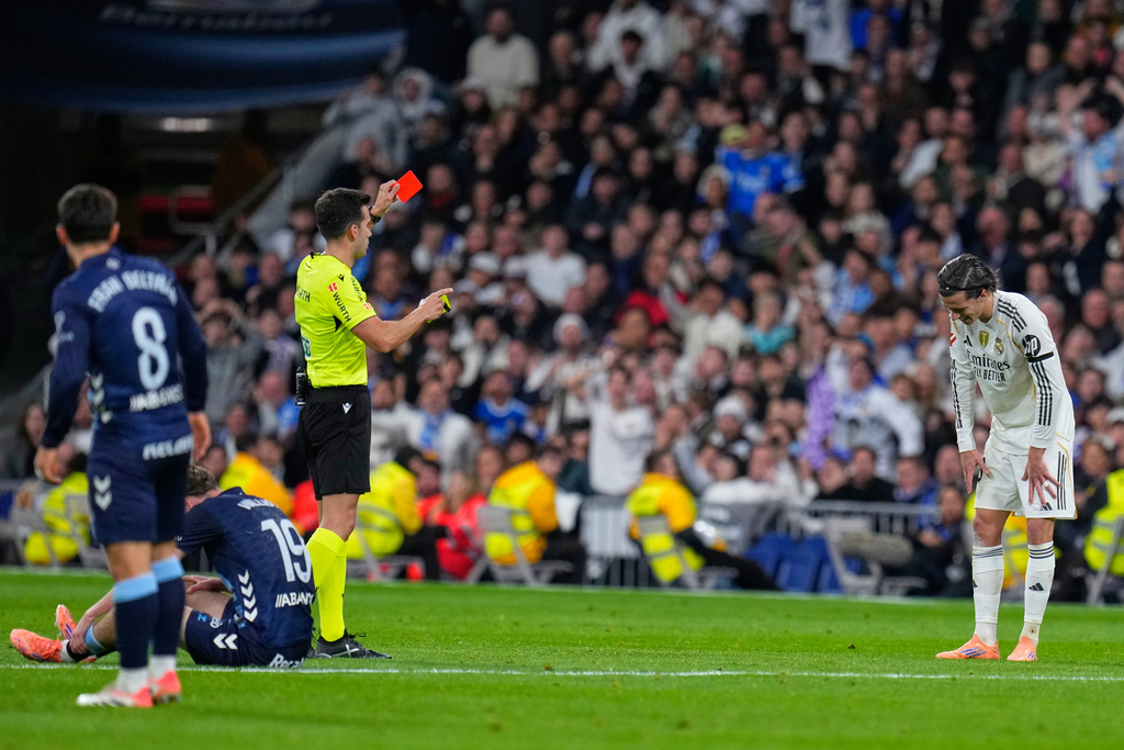 Real Madrid's Alvaro Carreras gets a red card during the Spanish La Liga soccer match between Real Madrid and Celta Vigo in Madrid, Spain, Sunday, Dec. 7, 2025. (AP Photo/Manu Fernandez)