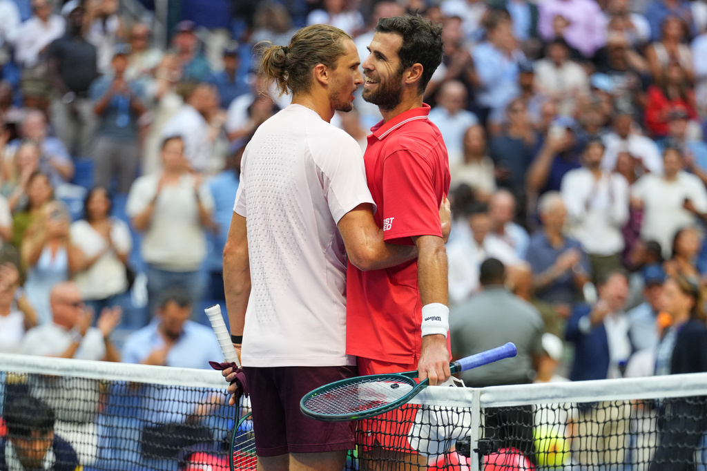 Alexander Zverev, of Germany, left, and Karen Khachanov, of Russia, right, meet at the net after Zverev won their match during the men's singles semifinals of the U.S. Open tennis championships, Friday, Sept. 11, 2026, in New York. (AP Photo/Kirsty Wigglesworth)