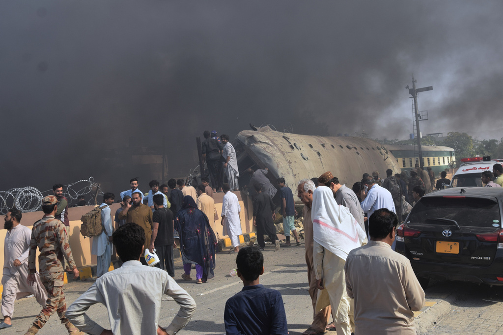 Paramilitary soldiers and volunteers recover victims from an overturned train coach on a railway track at the site of bomb explosion, in Quetta, Pakistan, Sunday, May 24, 2026. (AP Photo/Arshad Butt)