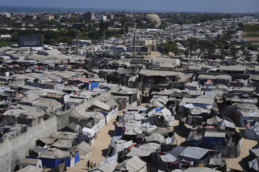 Displaced Palestinians walks through a tent camp in Muwasi, an area that Israel has designated as a safe zone, in Khan Younis southern Gaza Strip, Wednesday, Sept. 10, 2025. (AP Photo/Jehad Alshrafi)
