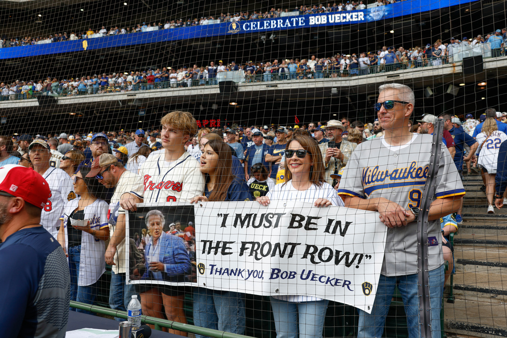 Fans hold a sign during the Bob Uecker Celebration of Life ceremony before a baseball game between the San Francisco Giants and the Milwaukee Brewers, Sunday, Aug. 24, 2025, in Milwaukee. (AP Photo/Jeffrey Phelps)