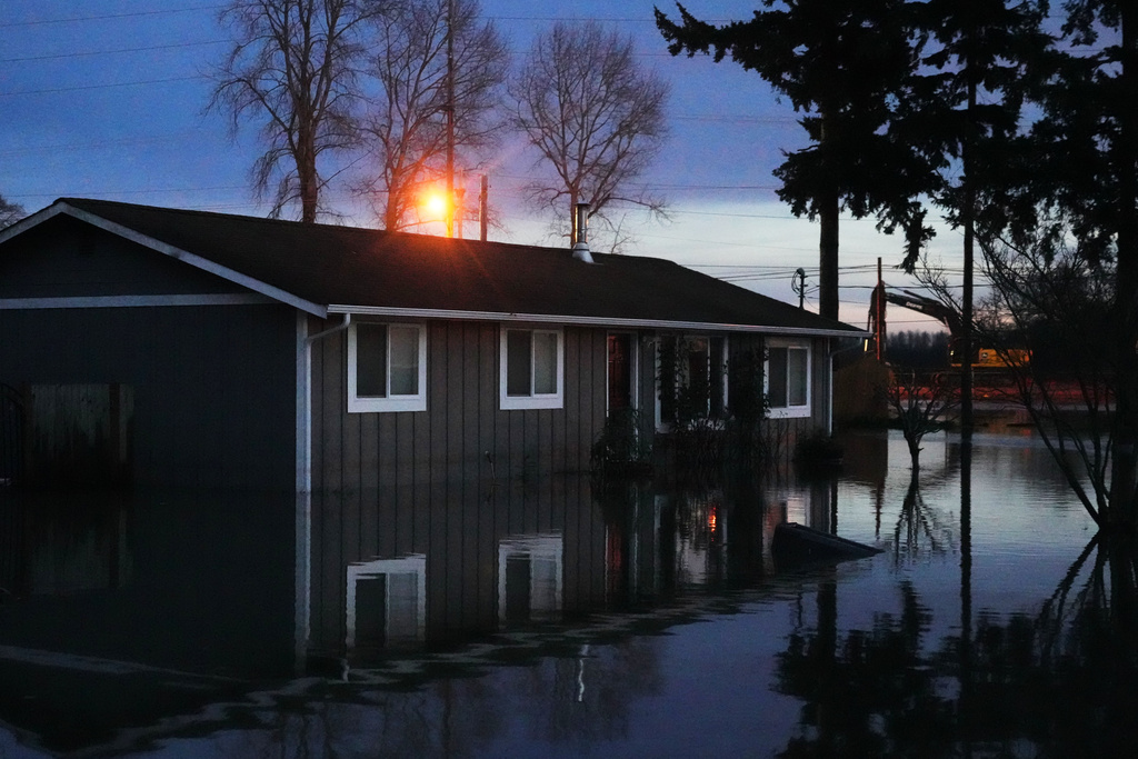 Floodwaters surround a home after heavy rains led to historic flooding in the region Saturday, Dec. 13, 2025, in Burlington, Wash. (AP Photo/Lindsey Wasson)
