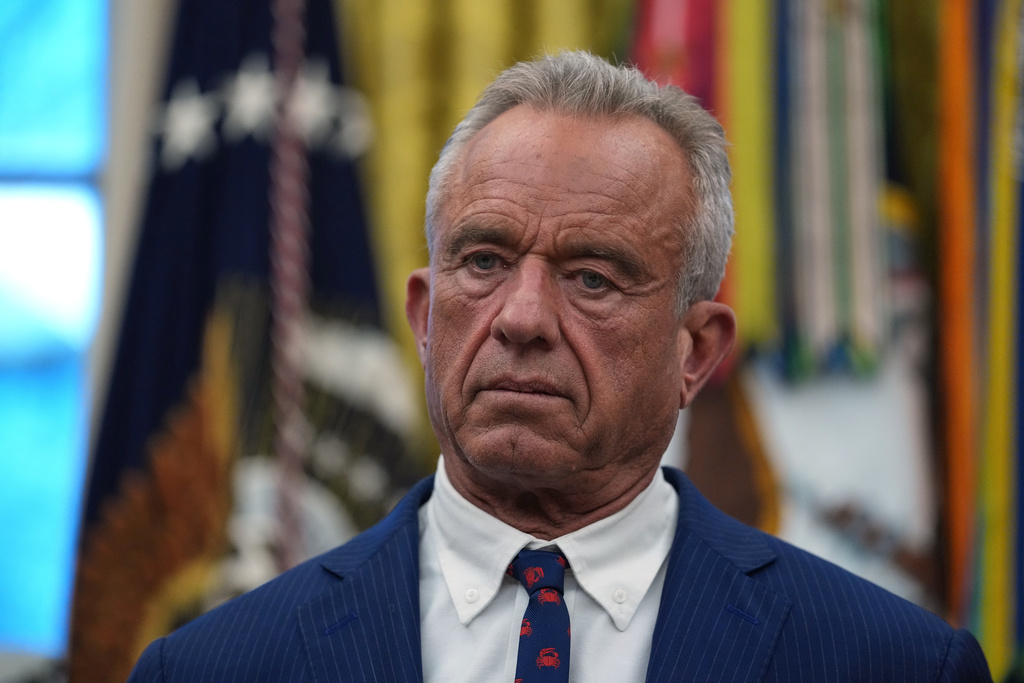 Health and Human Services Secretary Robert F. Kennedy Jr. listens as President Donald Trump speaks at an event on addiction recovery in the Oval Office of the White House, Thursday, Jan. 29, 2026, in Washington. (AP Photo/Allison Robbert)