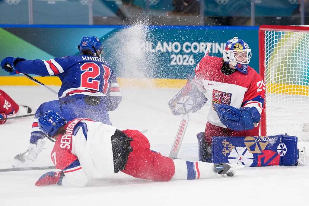 Czechia's Klara Seroiszkova slides into Czechia's Klara Peslarova, right, as United States' Hilary Knight scores her sides fourth goal during a preliminary round match of women's ice hockey between United States and Czechia at the 2026 Winter Olympics, in Milan, Italy, Thursday, Feb. 5, 2026. (AP Photo/Petr David Josek)