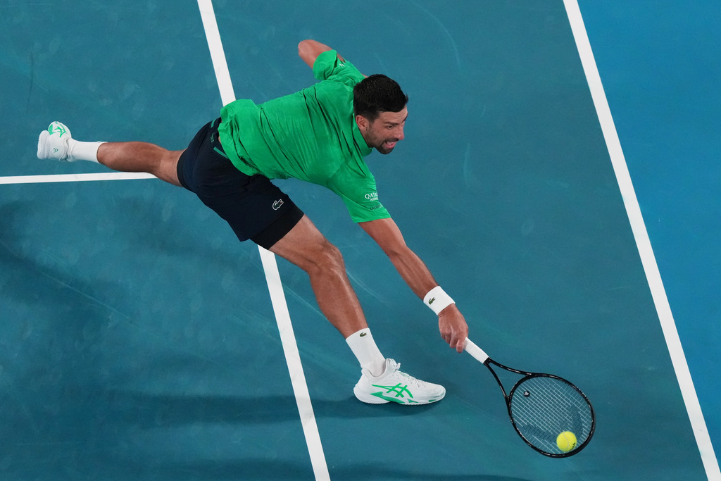 Novak Djokovic of Serbia plays a backhand return to Pedro Martinez of Spain during their first round match at the Australian Open tennis championship in Melbourne, Australia, Monday, Jan. 19, 2026. (AP Photo/Aaron Favila)