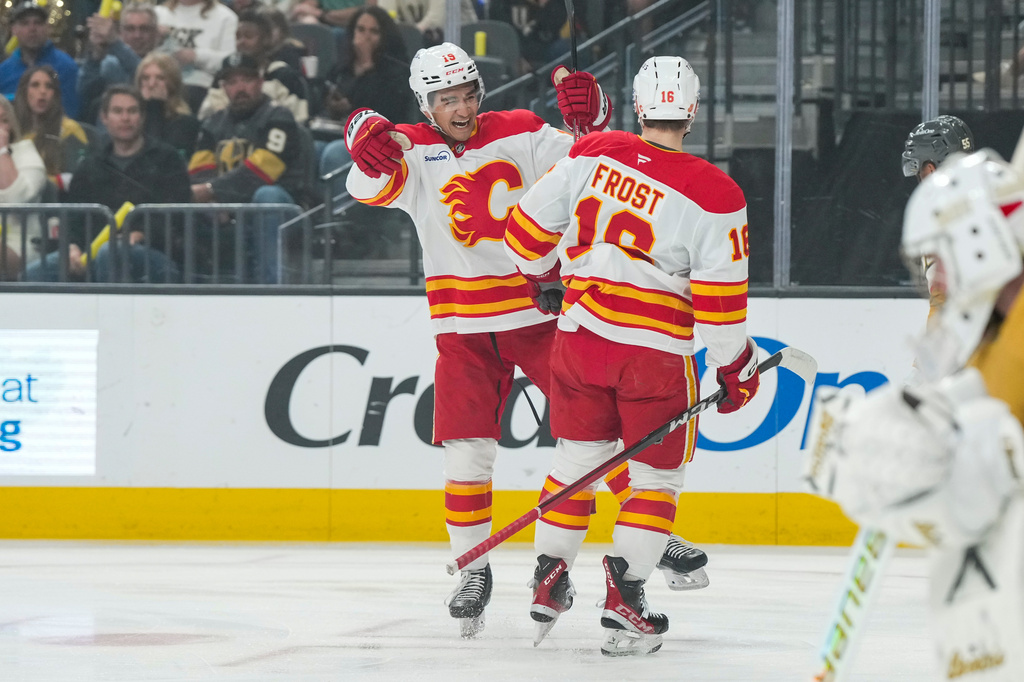 Calgary Flames center John Beecher (18) celebrates after his goal with defenseman Zayne Parekh (19) during the first period of an NHL hockey game against the Vegas Golden Knights, Thursday, April 2, 2026, in Las Vegas. (AP Photo/Candice Ward)