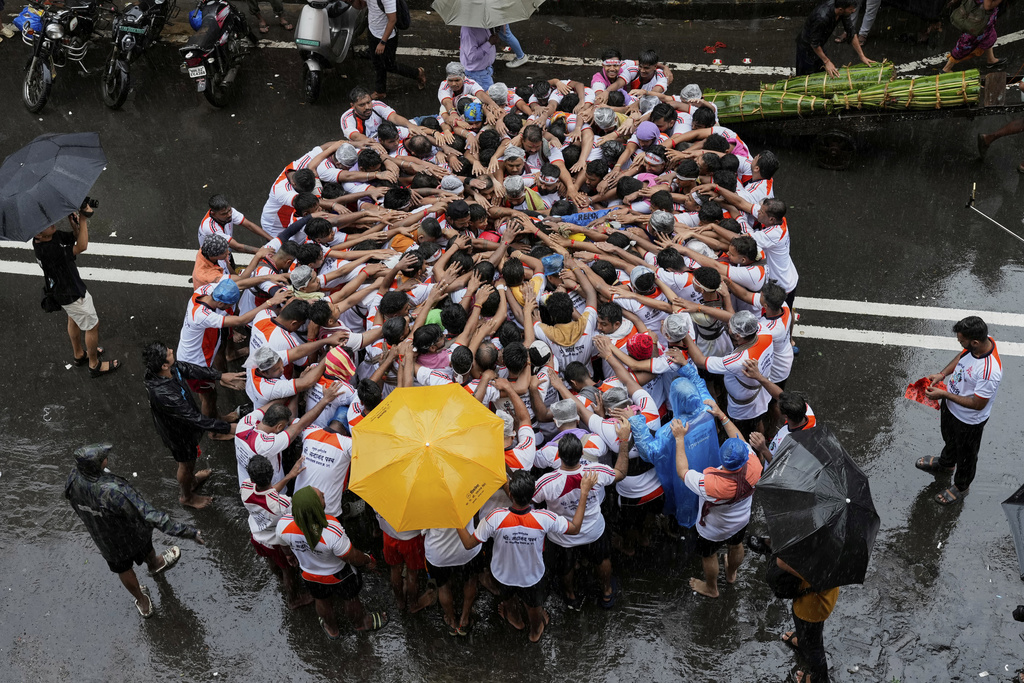 Devotees try to form a human pyramid to break a clay pot containing curd hanging above during the celebrations to mark the Hindu festival of Janmashtami in Mumbai, India, Saturday, Aug. 16, 2025. (AP Photo/Rajanish Kakade)