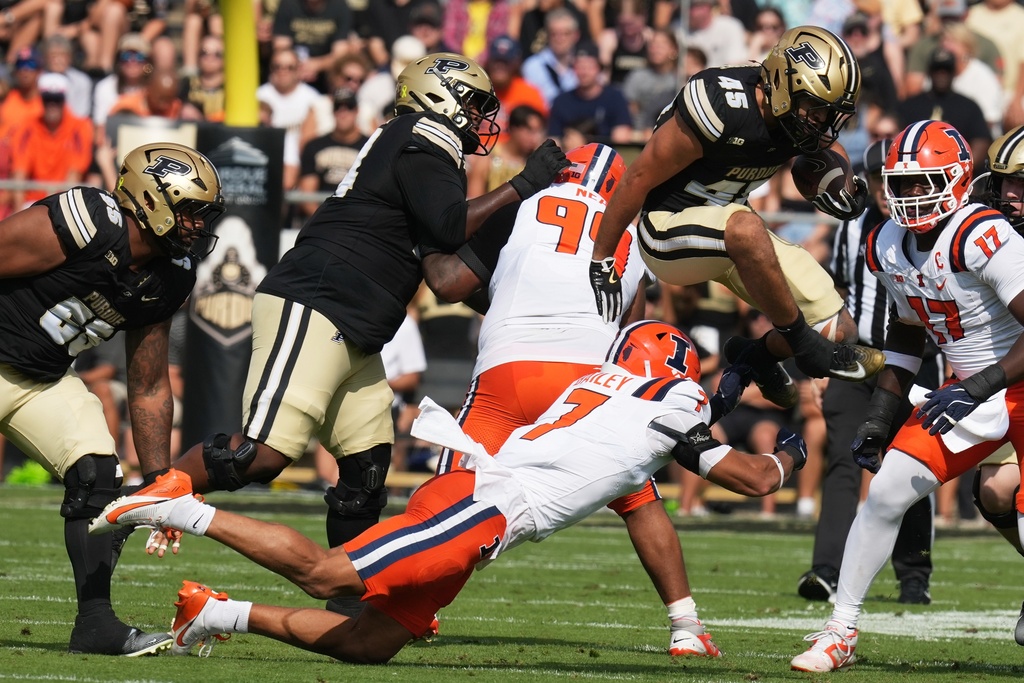 Purdue running back Devin Mockobee (45) leaps over Illinois defensive back Matthew Bailey (7) during the first half of an NCAA college football game, Saturday, Oct. 4, 2025, in West Lafayette, Ind. (AP Photo/Darron Cummings)