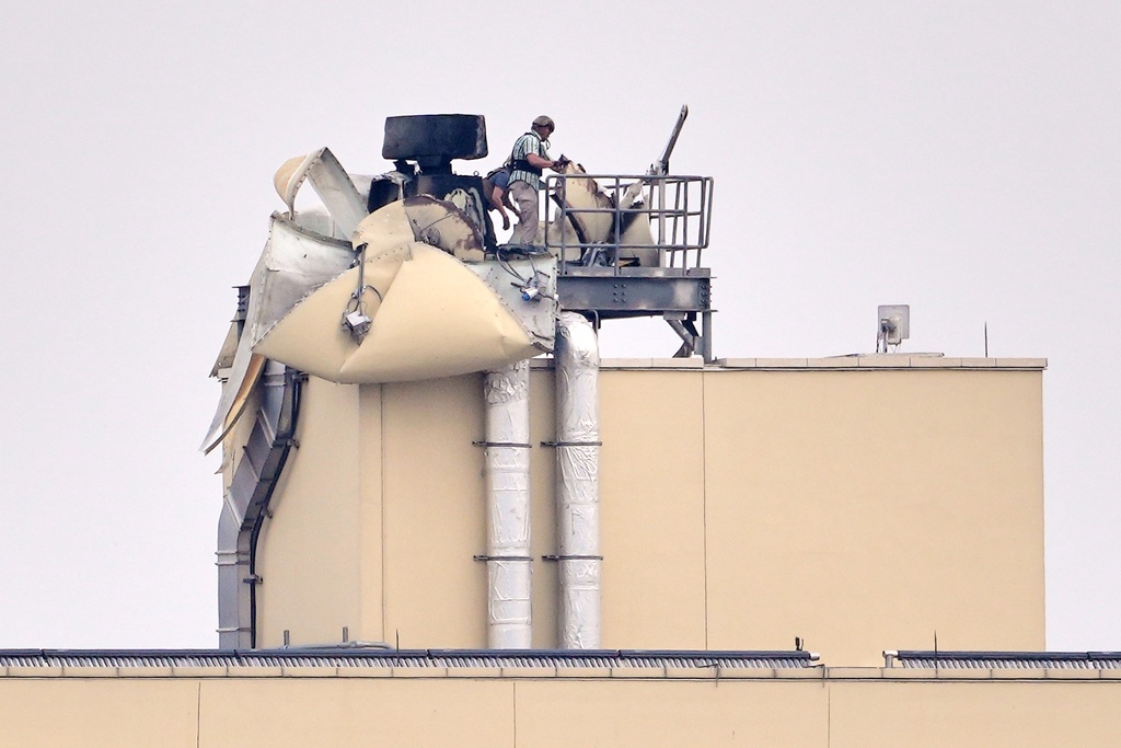 U.S. embassy personnel inspect the damage caused by a bombing in Baghdad, Saturday, March 14, 2026. (AP Photo/Hadi Mizban)