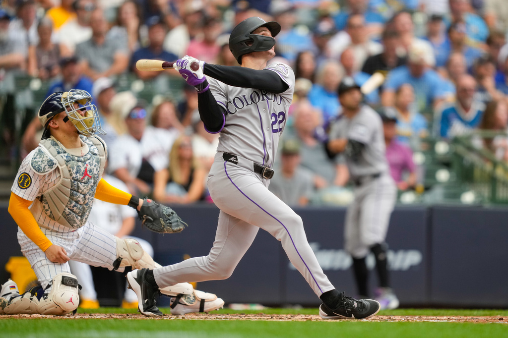 Colorado Rockies designated hitter Mickey Moniak hits a sacrifice fly, allowing Willi Castro to score, as Milwaukee Brewers catcher William Contreras, left, looks on during the fourth inning of a baseball game Friday, July 24, 2026, in Milwaukee. (AP Photo/Kayla Wolf)