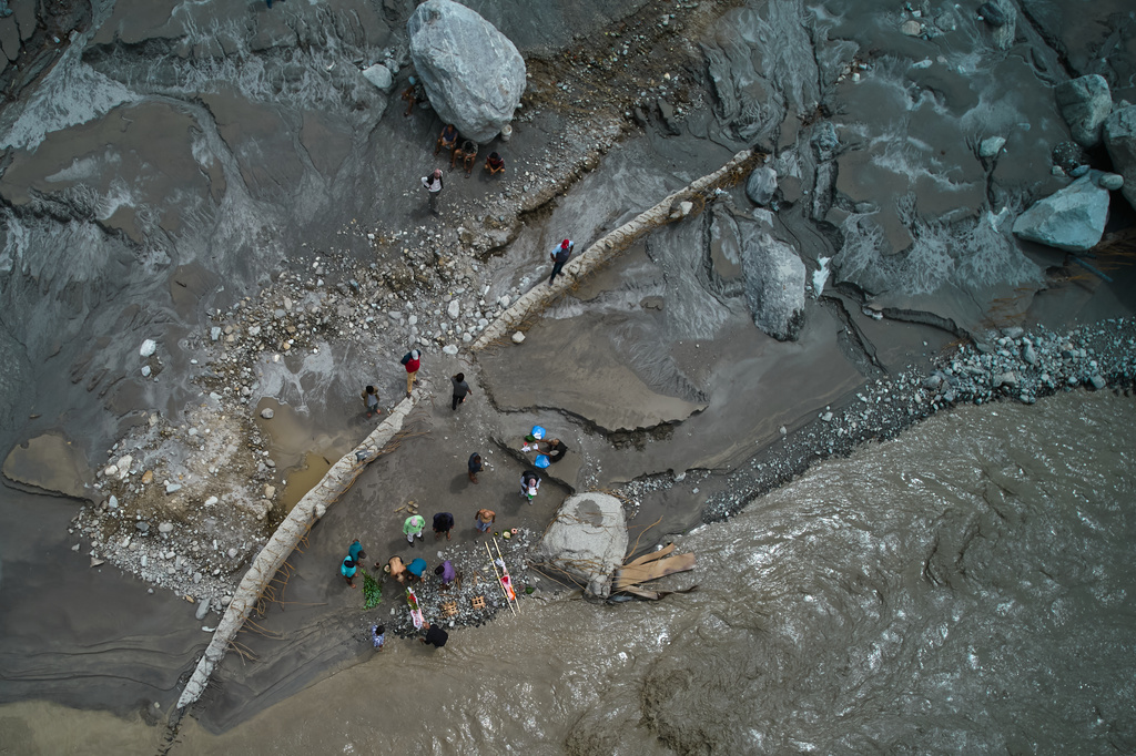 People whose relatives remain missing and are presumed dead following flash floods perform symbolic last rites on the banks of the swollen Trishuli River in Nepal's Nuwakot district, Wednesday, Sept. 2, 2026. (AP Photo/Rajesh Kumar Singh)