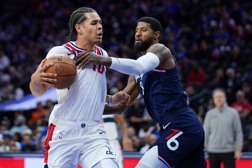 Washington Wizards' Kyshawn George, left, tries to get past Philadelphia 76ers' Paul George during the first half of an NBA basketball game Tuesday, Dec. 2, 2025, in Philadelphia. (AP Photo/Matt Slocum)