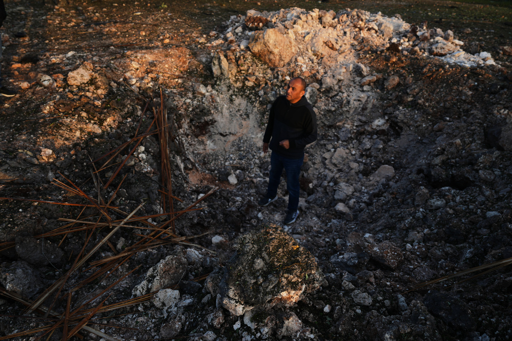 A man looks a the site struck by an Iranian missile in Zarzir, northern Israel, Friday, March 13, 2026. (AP Photo/Ariel Schalit)