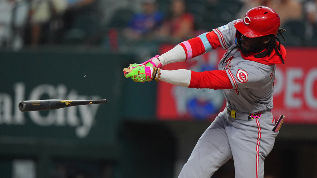 Cincinnati Reds' Elly de la Cruz breaks his bat while hitting a single, scoring teammate Matt McLain, during the first inning of a baseball game against the Texas Rangers, Saturday, April 4, 2026, in Arlington, Texas. (AP Photo/LM Otero)