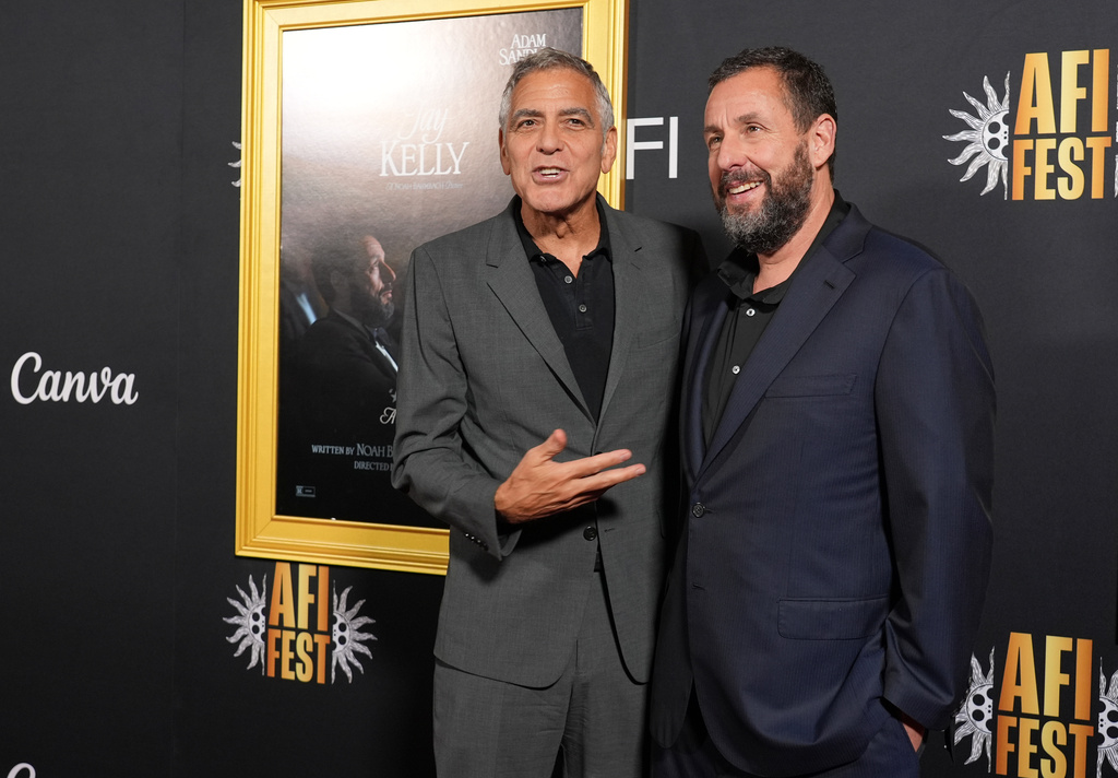 George Clooney, left, and Adam Sandler, cast members in "Jay Kelly," pose together at the AFI Fest premiere of the film on Thursday, Oct. 23, 2025, at TCL Chinese Theatre in Los Angeles. (AP Photo/Chris Pizzello)