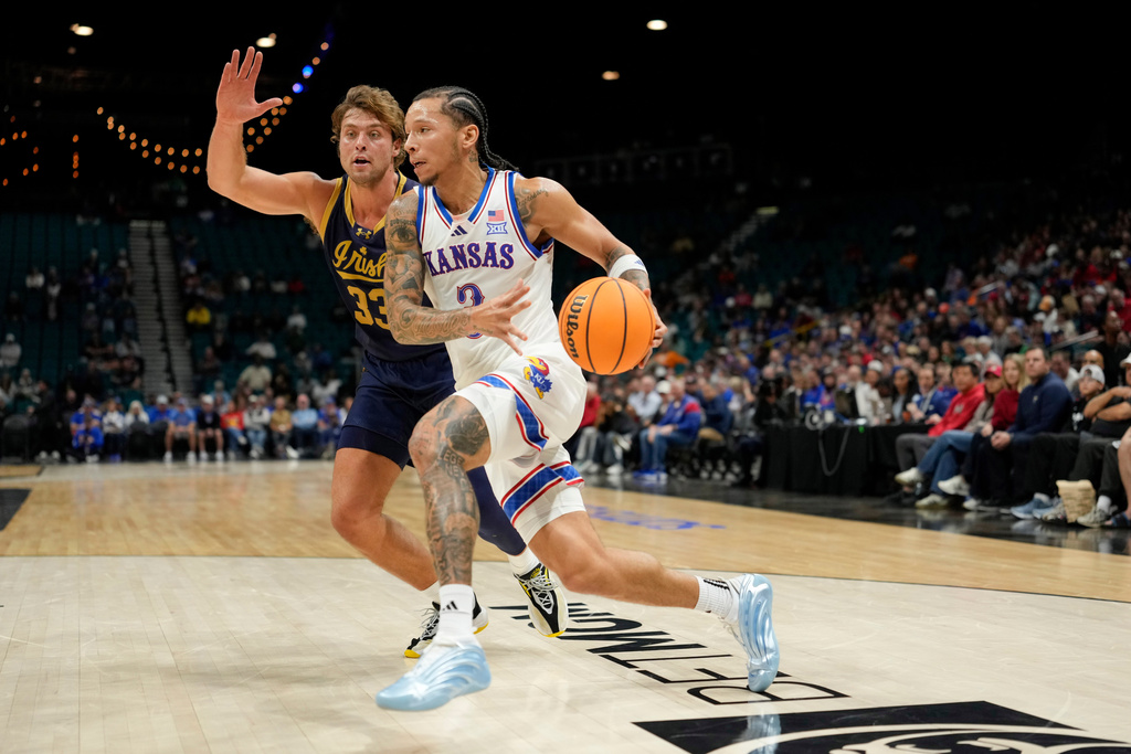 Kansas guard Tre White drives the ball against Notre Dame forward Carson Towt (33) during the first half of an NCAA college basketball game, Monday, Nov. 24, 2025, in Las Vegas. (AP Photo/Lucas Peltier)