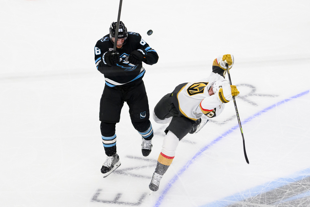 Utah Mammoth defenseman Nate Schmidt (88) checks Vegas Golden Knights left wing Brandon Saad, right, away from the puck during the first period of an NHL hockey game, Thursday, Nov. 20, 2025, in Salt Lake City, Utah. (AP Photo/Tyler Tate)