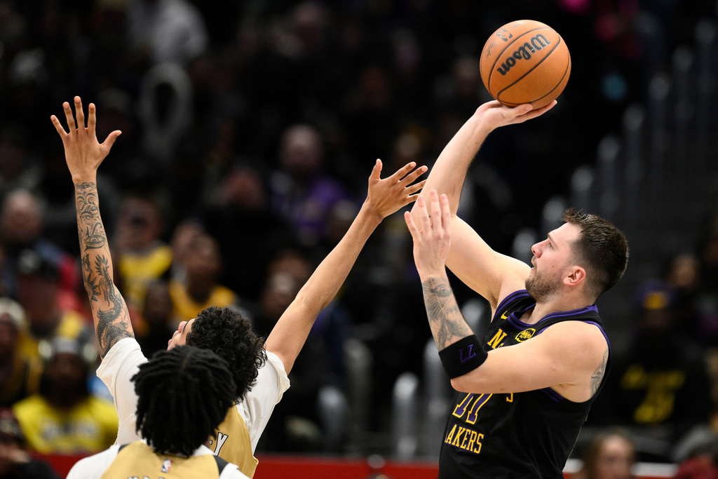 Los Angeles Lakers guard Luka Doncic, right, looks to shoot during the first half of an NBA basketball game against the Washington Wizards, Friday, Jan. 30, 2026, in Washington. (AP Photo/Nick Wass)