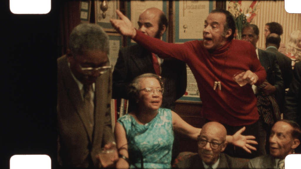 This image released by Neon shows, sitting from left, Jean Blackwell Hutson, Eubie Blake, and Irvin C. Miller, standing from left, Aaron Douglas, Nathan Huggins, and Richard Bruce Nugent in a scene from the documentary "Once Upon a Time in Harlem." (Neon via AP)