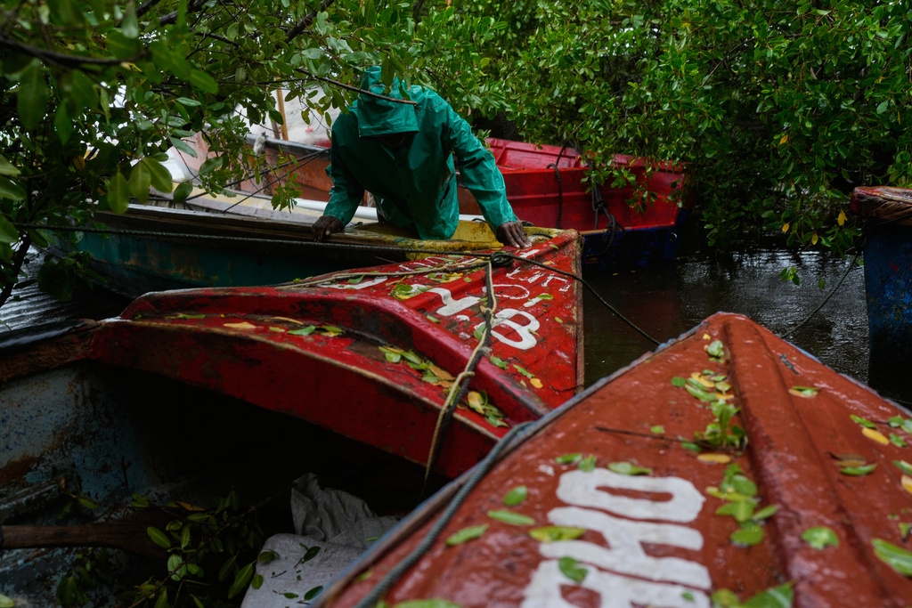 A fisherman ties boats in preparation for the forecasted arrival of Hurricane Melissa in Old Harbour, Jamaica, Monday, Oct. 27, 2025. (AP Photo/Matias Delacroix)