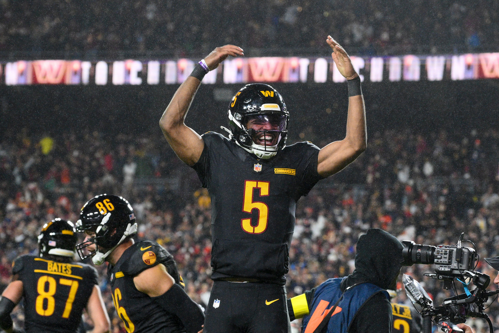 Washington Commanders quarterback Jayden Daniels (5) celebrates a touchdown pass during the second half of an NFL football game against the Chicago Bears, Monday, Oct. 13, 2025, in Landover, Md. (AP Photo/Nick Wass)
