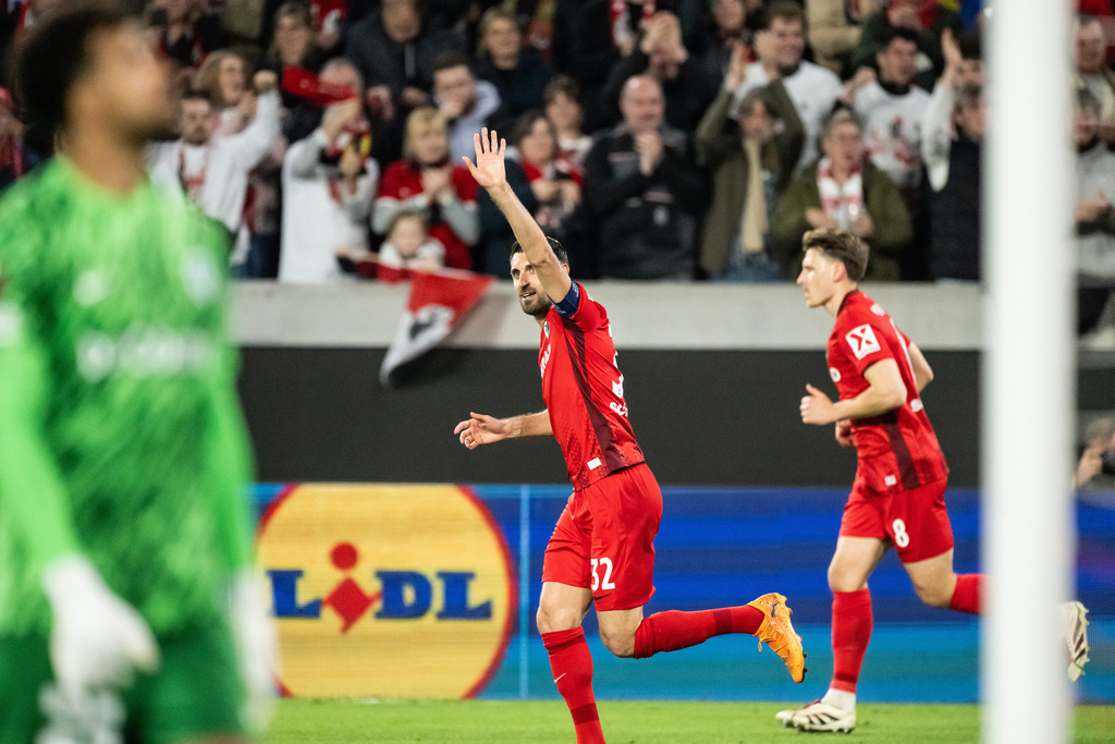 Freiburg's Vincenzo Grifo, center, celebrates after his teammate Mattias Ginter scored the opening goal during the Europa League round of sixteen second leg soccer match between SC Freiburg and KRC Genk in Freiburg, Germany, Thursday, March 19, 2026. (Silas Stein/dpa via AP)