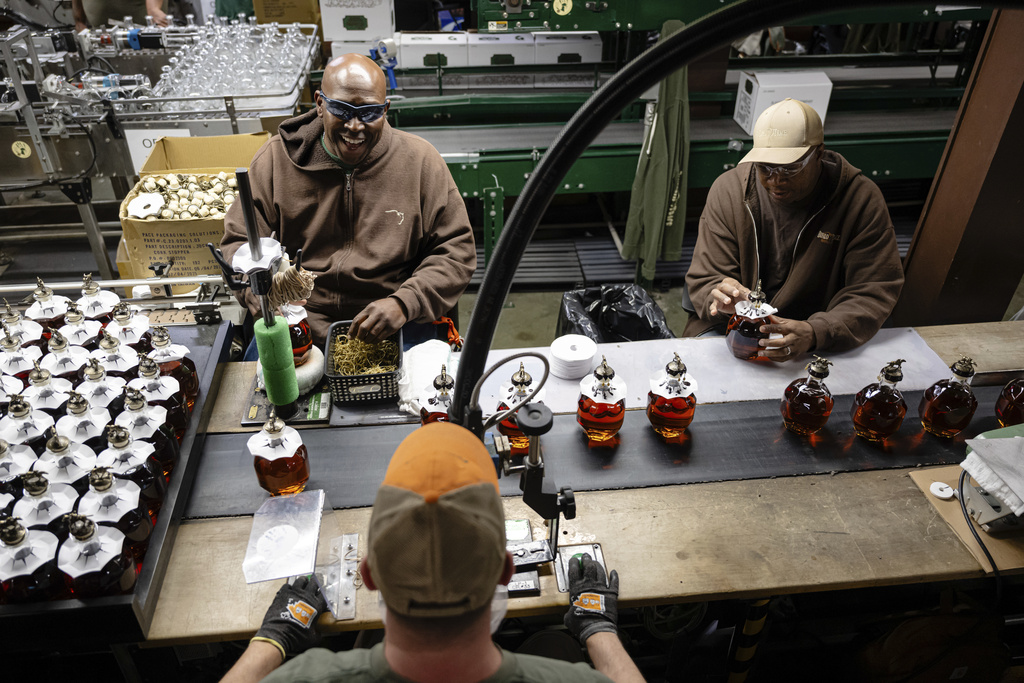 Workers process freshly filled bottles of Blanton's bourbon in a bottling area at Buffalo Trace Distillery on Sept. 16, 2025, in Frankfort, Ky. (AP Photo/Jon Cherry)