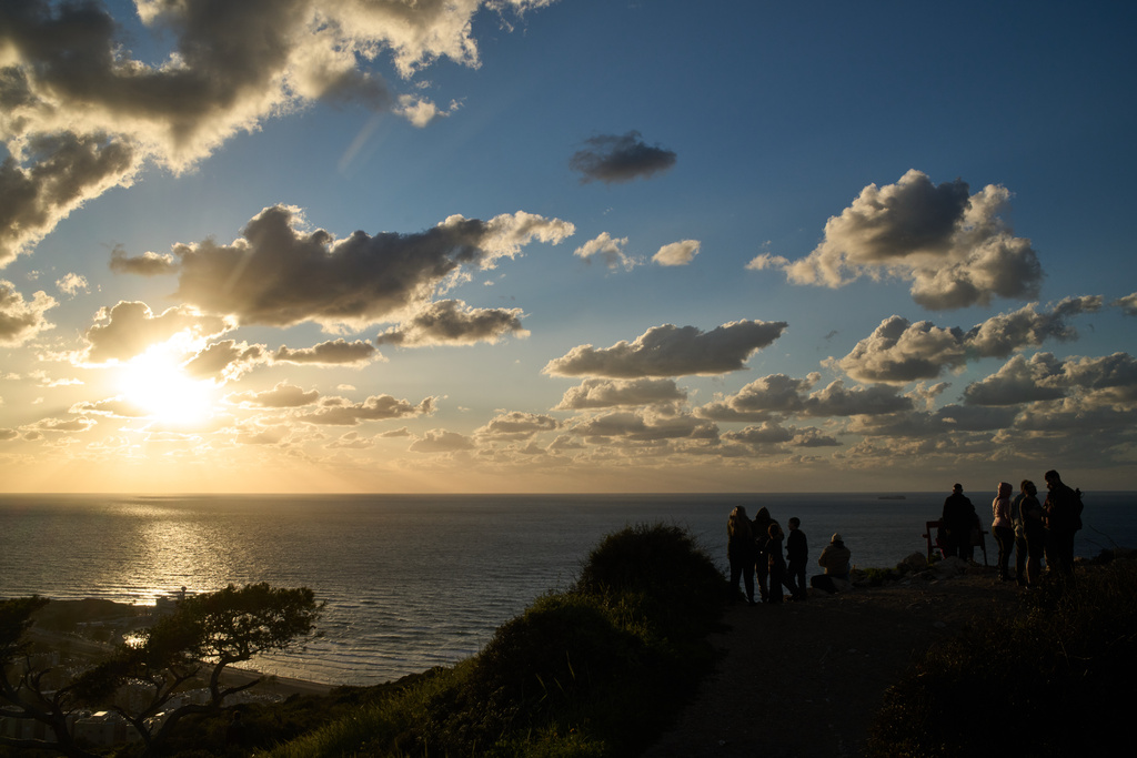 People gather at a lookout to look for the possible arrival of the US Navy's aircraft carrier USS Gerald R. Ford in the Mediterranean Sea near the coast of Haifa, northern Israel, Friday, Feb. 27, 2026. (AP Photo/Leo Correa)