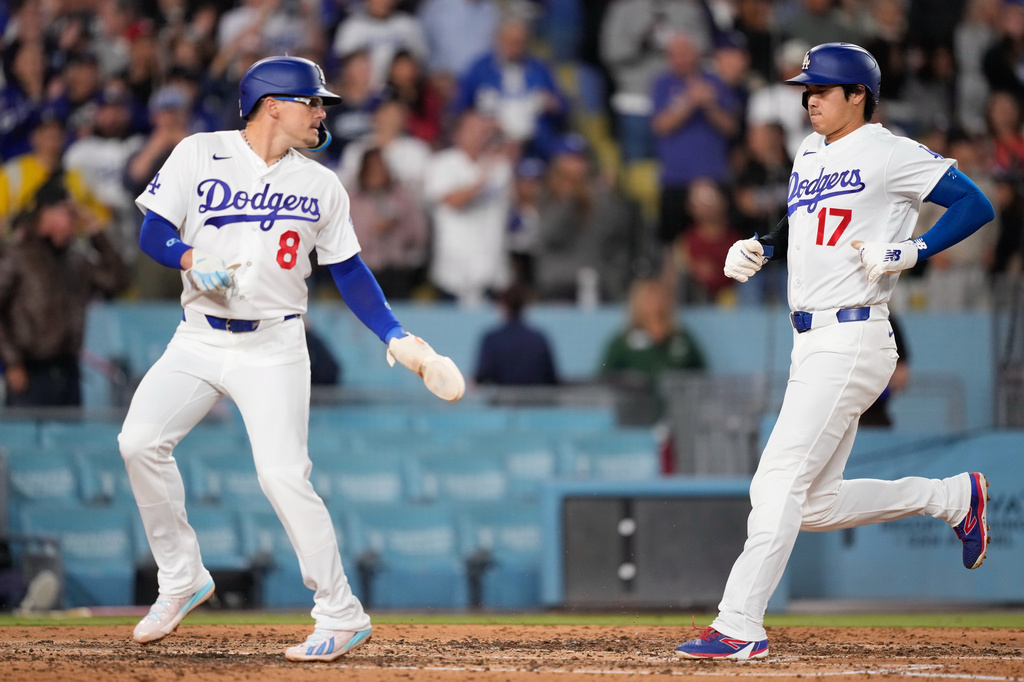 Los Angeles Dodgers' Kiké Hernández, looks back at Shohei Ohtani as they score on a double by Andy Pages during the fourth inning of a baseball game Tuesday, May 26, 2026, in Los Angeles. (AP Photo/Mark J. Terrill)