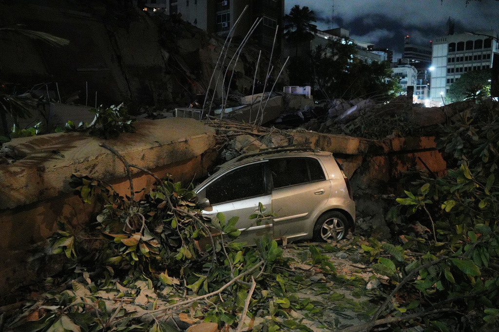 A car smashed by a collapsed building after an earthquake in Caracas, Venezuela, Wednesday, June 24, 2026. (AP Photo/Adrian Naranjo)