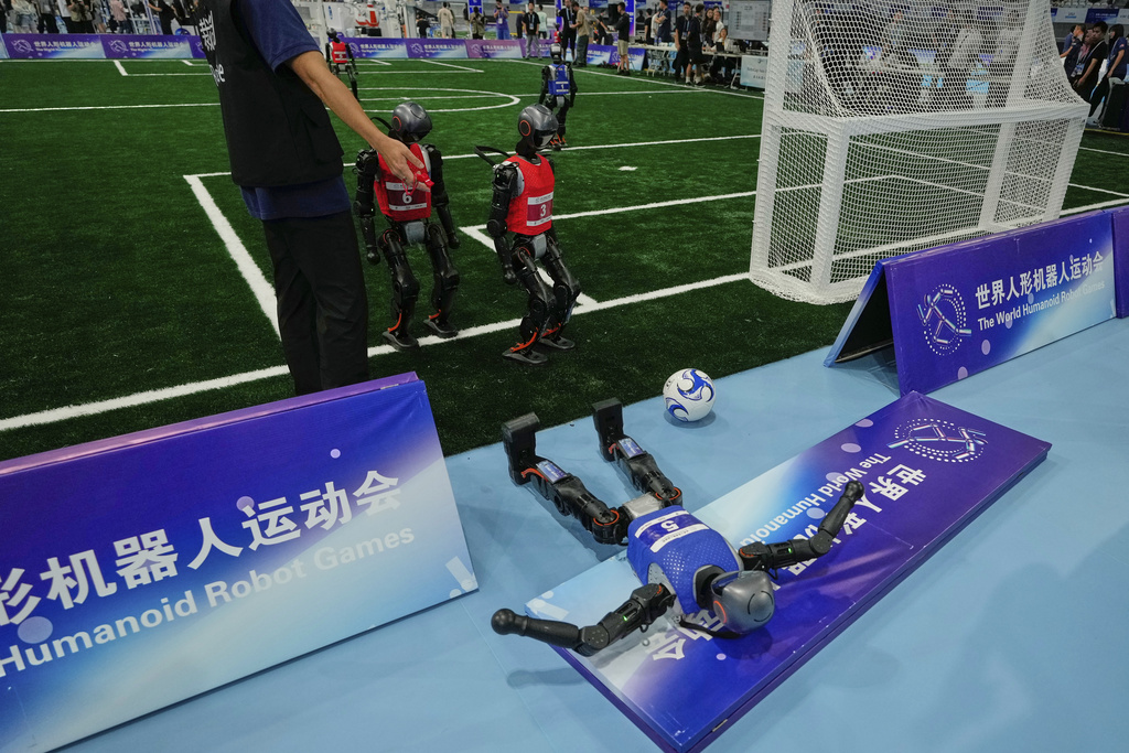 A robot crashes during a soccer match at the World Humanoid Robot Games in Beijing, China, Friday, Aug. 15, 2025. (AP Photo/Mahesh Kumar A.)