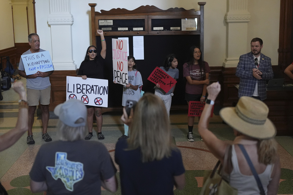 Protesters gather outside of the House Chamber where Democratic Texas Rep. Nicole Collier refuses to leave due to a required law enforcement escort, Tuesday, Aug. 19, 2025, in Austin, Texas. (AP Photo/Eric Gay)