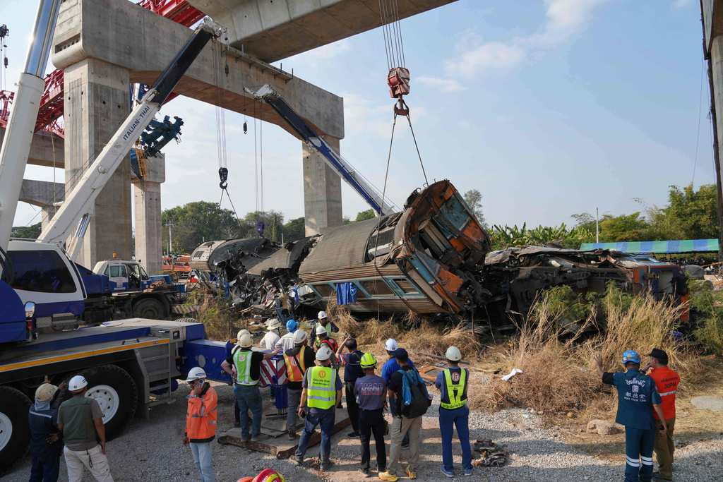 Rescuers try to lift the wreckage after a construction crane fell into a passenger train in Nakhon Ratchasima province, Thailand, Wednesday, Jan.14, 2026. (AP Photo/Sakchai Lalit))