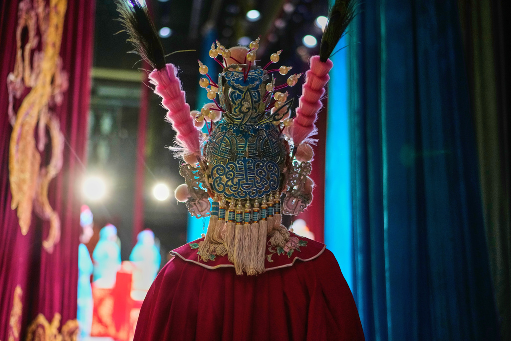 A Peking Opera actress applies makeup backstage before a show in Beijing, China, Sunday, Sept. 7, 2025. (AP Photo/Mahesh Kumar A.)