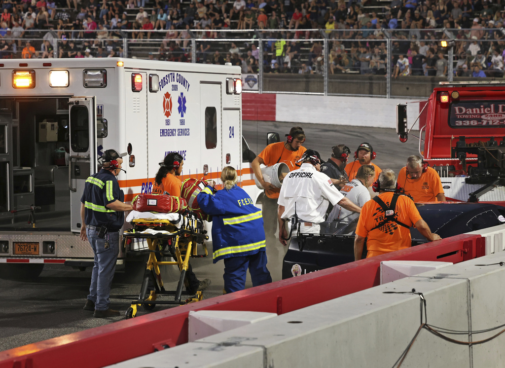 Track crew work to remove Sportsman Series driver Robbie Brewer from his car after suffering a medical emergency on the restart on lap 16 of the first 20-lap Sportsman Series race at Bowman Gray Stadium, on Saturday, Aug. 9, 2025, in Winston-Salem, N.C. (Walt Unks/The Winston-Salem Journal via AP)
