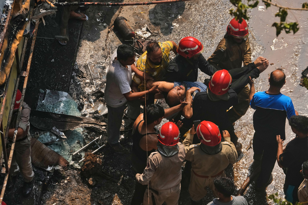 Firefighters rescue a foreign national from a hotel fire in New Delhi, India, Wednesday, June 3, 2026. (AP Photo/Manish Swarup)